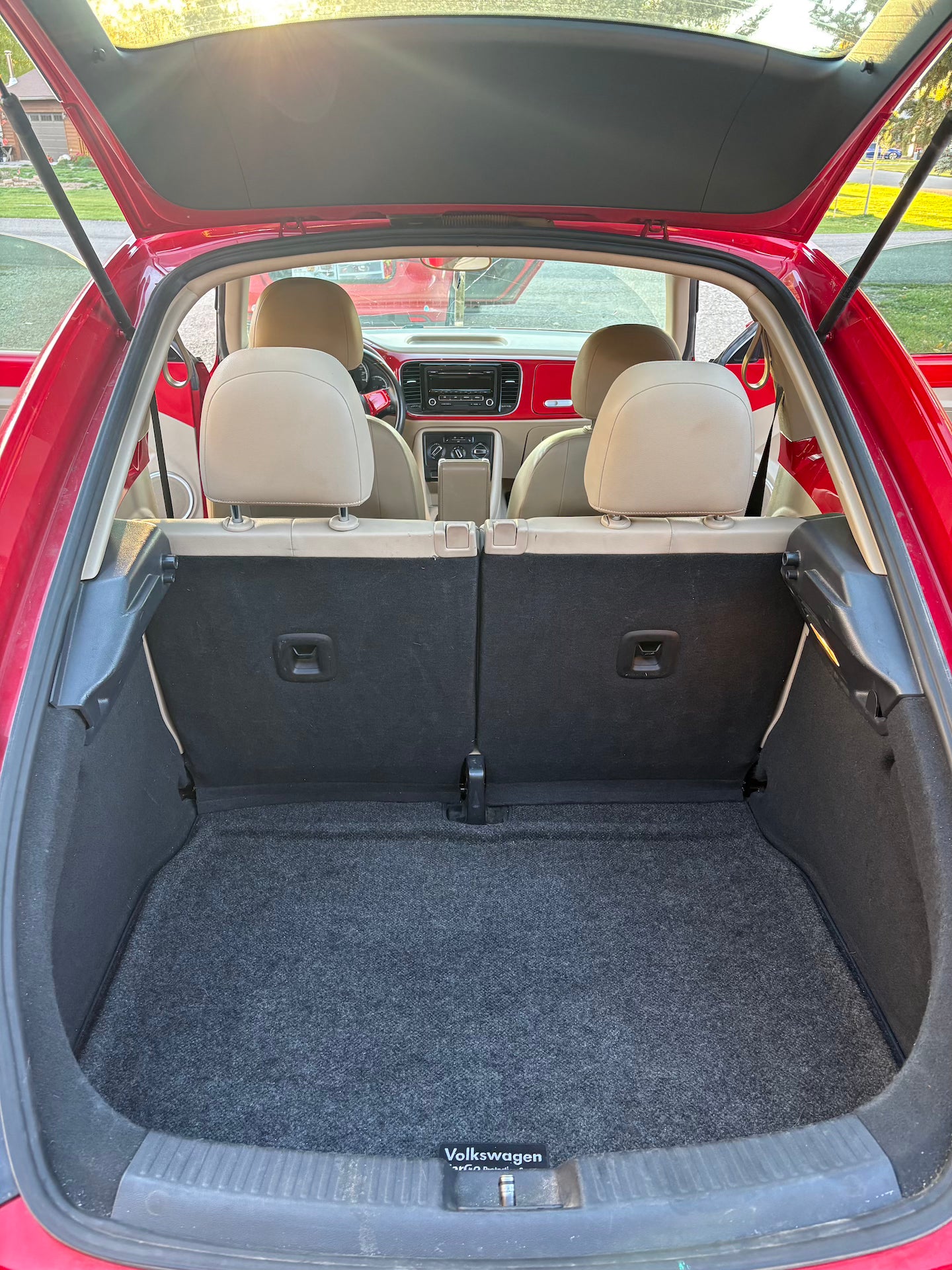 Open trunk of a red car with gray interior